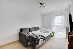 Una sala de estar con un sofá y una ventana. en ParisCharm, en Pantin