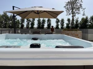 a large jacuzzi tub with an umbrella in it at Casa MarFe in Grottaglie