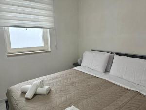 a white bedroom with a bed with a towel on it at Casa MarFe in Grottaglie