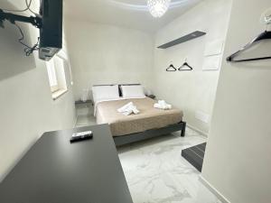 a small bedroom with a bed and a table at Casa MarFe in Grottaglie