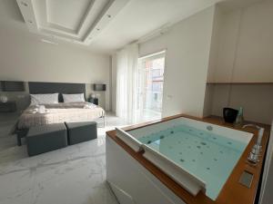 a large bathroom with a tub in front of a bed at Casa MarFe in Grottaglie