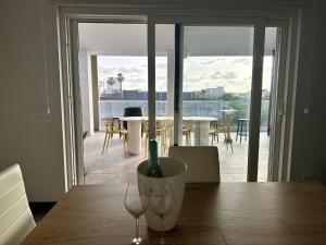 a table with two wine glasses and a view of a balcony at Casa MarFe in Grottaglie