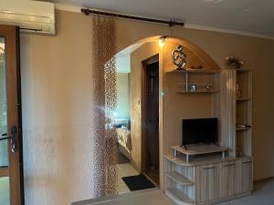 sala de estar con TV y espejo en Paunovi Guest House, en Primorsko