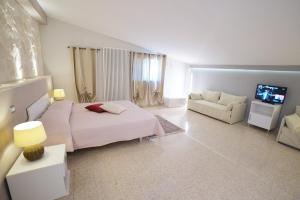 sypialnia z łóżkiem, kanapą i telewizorem w obiekcie Agriturismo Nonna Rosa w mieście Matera