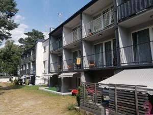 an apartment building with balconies and a yard at Apart & Plus 2 in Okuninka