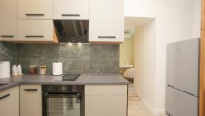 a kitchen with white cabinets and a refrigerator at Red House Corner in Marijampolė