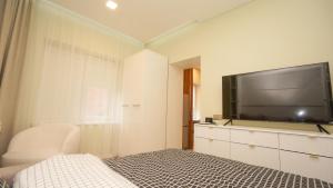 a bedroom with a flat screen tv and a bed at Red House Corner in Marijampolė