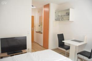 a room with a bed and a desk and a television at Saarbrücken City Apartments in Saarbrücken