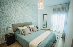 a bedroom with a bed with blue walls and a mirror at Ondas do Mar Boutique Stays - Portonovo 1 in Portonovo