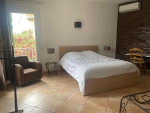 a bedroom with a bed and a chair and a window at Chambres privées dans Maison en Provence in Fontvieille