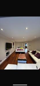 a living room with two couches and a flat screen tv at Bramble Close in Chalfont Saint Peter
