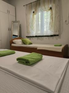 a bedroom with two beds and a window at Apartman Zora in Neum