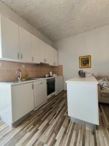 a kitchen with white cabinets and a counter top at Apartman Zora in Neum