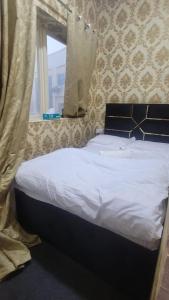 ドバイにあるEmirates Apartments Room Capsulesのベッド(白いシーツ付)、窓のあるベッドルーム