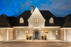 卑尔根Hopsneset Luxury Villa的黑色屋顶的大型白色房屋