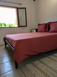 a bedroom with a large bed with a mirror and a window at Maison de campagne in Bonifacio
