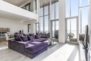 een woonkamer met een paarse bank en grote ramen bij Penthouse With The Best Views! in Barcelona