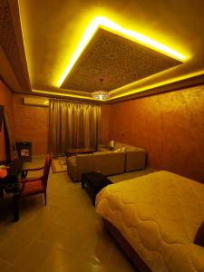 a hotel room with two beds and a couch at Hotel Saghro in Tinerhir