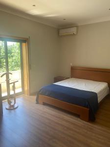 ein Schlafzimmer mit einem Bett und einem großen Fenster in der Unterkunft A Quinta do Presidente 