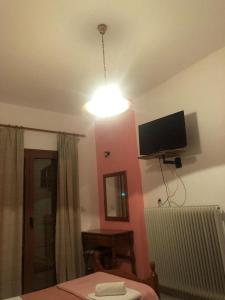 a room with a bed and a tv on the wall at Villa Rea in Melissópetra