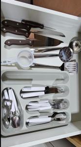 a drawer filled with lots of silver utensils at JM03 Apartamento com Ar Condicionado e Garagem in Dourados