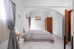 a bedroom with a bed in a white room at Exquisite Retreat For Two in Archangelos