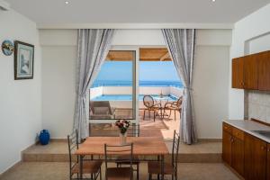 a kitchen and dining room with a view of the ocean at Exquisite Retreat For Two in Archangelos