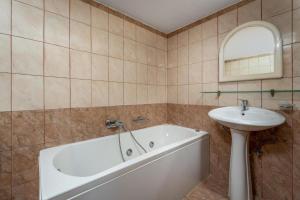 a bathroom with a bath tub and a sink at Exquisite Retreat For Two in Archangelos +9 photos