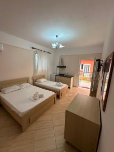 a bedroom with two beds and a kitchen in it at Elysian Sunset Studios in Himare