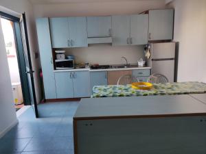 a kitchen with white cabinets and a counter top at Casa del Sole in SantʼAndrea Apostolo dello Ionio