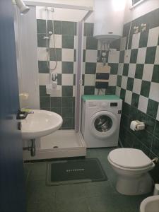 a bathroom with a toilet sink and a washing machine at Casa del Sole in SantʼAndrea Apostolo dello Ionio +16 photos