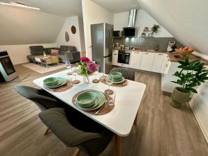 a white table with plates on it in a living room at Familie oder beruflich - 2 Schlafzimmer - 3 Betten - Geräumig - Küche - Gemütlich in Bad Lippspringe