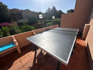 a table on a balcony with a bench and flowers at Il fresco patio appartamento Porto Rotondo in Porto Rotondo