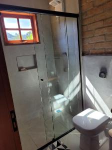 a bathroom with a shower and a toilet at Chalé Rústico Moderno no Cantagalo in São Bento do Sapucaí