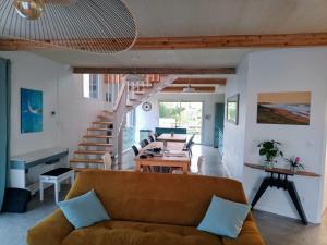 una sala de estar con un sofá y una mesa en 2 Maisons bois , Les conches, en Longeville-sur-Mer