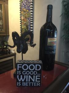 uma garrafa de vinho e um cartaz numa mesa ao lado de uma garrafa de vinho em Louisiana Cajun Mansion em Youngsville