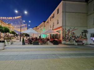 a street at night with tables and chairs and lights at Central Mangalia in Mangalia