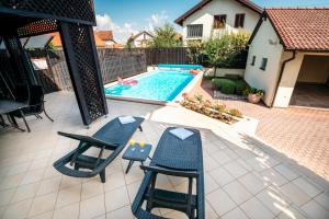 a patio with two chairs and a swimming pool at Villa Markus in Slavonski Brod