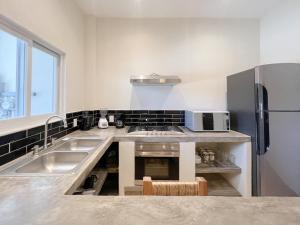 una cocina con fregadero y refrigerador en Best Location, Pristine, Secure, Newly Renovated, en Sayulita 12 fotos más