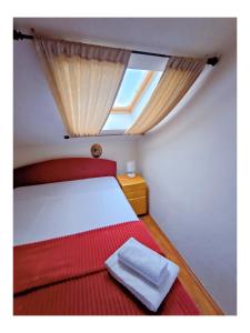 a bedroom with a bed with a skylight at Apartments Senko in Trpanj