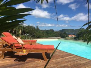 a pool with a deck with chairs and a swimming pool at Casa do Pombal in São Mateus