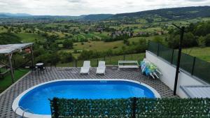 een zwembad met uitzicht op een heuvel bij Villa EXOTIC in Bihać