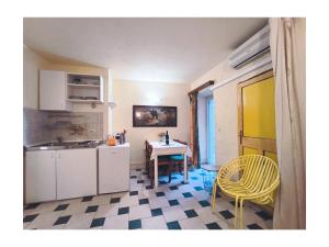 a kitchen with a table and yellow chairs in a room at Apartments Senko in Trpanj