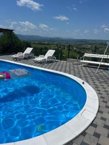 een zwembad met twee ligstoelen en uitzicht op het landschap bij Villa EXOTIC in Bihać