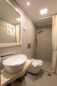 a bathroom with a sink and a toilet and a mirror at Ellies Secret Nest - 1bd 3pl in Spílion +13 photos