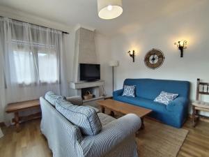 a living room with a blue couch and two chairs at Covas Beach Ocean in Lago