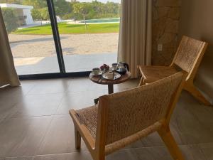 a room with a table and a chair and a table and a window at AVE SUITES CAMPESTRES Jalpan de Serra in Cunas
