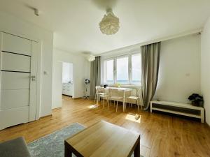 a living room with a table and a dining room at Cliff Apartment Redłowo in Gdynia