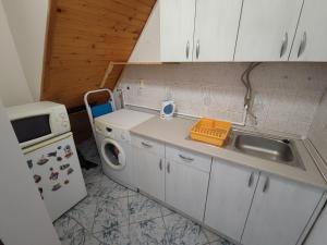 a small kitchen with a sink and a microwave at CityCenter - Cozy, tiny house in the city center in Subotica +7 photos