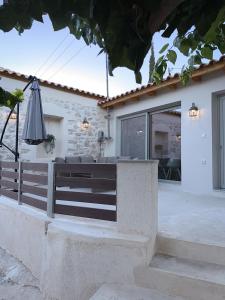 a house with a fence and an umbrella at Thetis, the Beach House in Nafplio